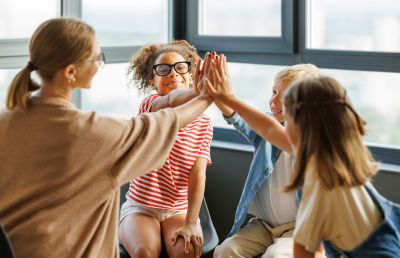children giving each other a team high-five with their teacher
