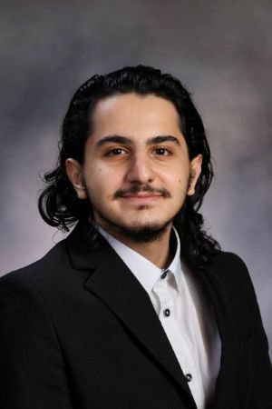 professional headshot of Zein who is wearing a black blazer