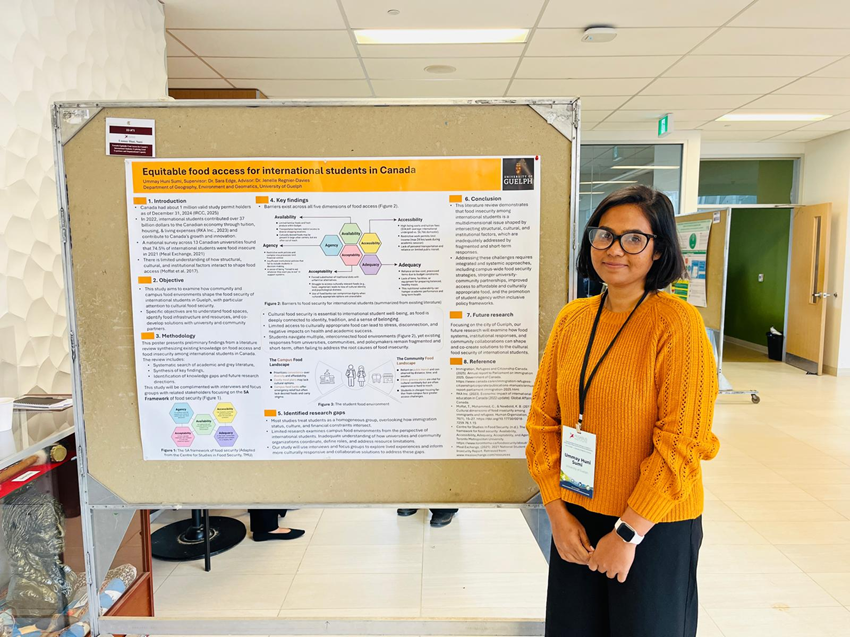Ummay stands with her poster presentation