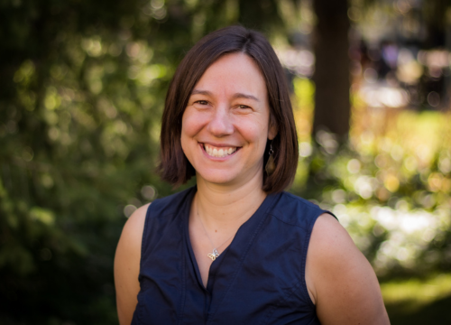 Headshot of Erin Nelson standing outdoors and smiling.