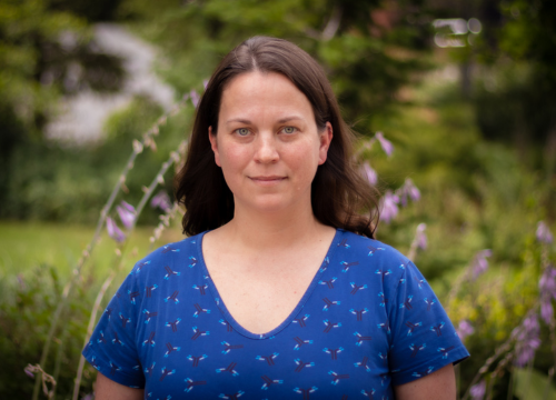 Headshot of Jennifer Murray, standing outside wearing a blue v-neck t-shirt.