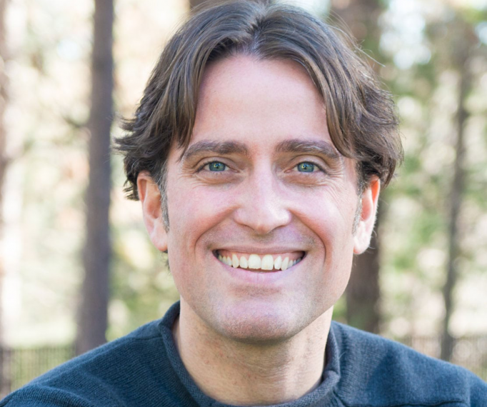 headshot of Dr. Philip Loring in front of a forest background