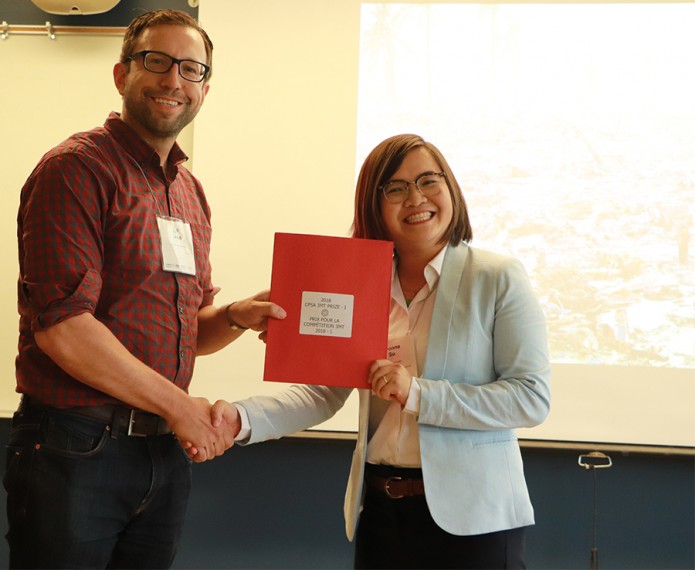 Yvonne Su shaking hands and receiving award for 3 minute thesis competition