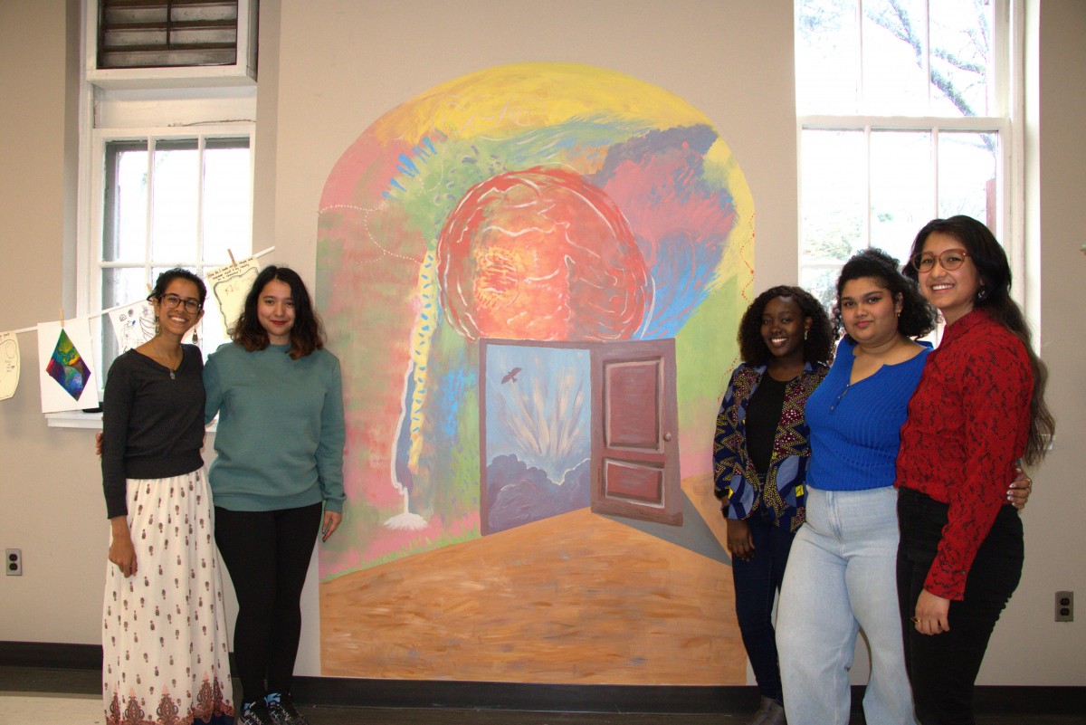 mentors and mentees in front of mural