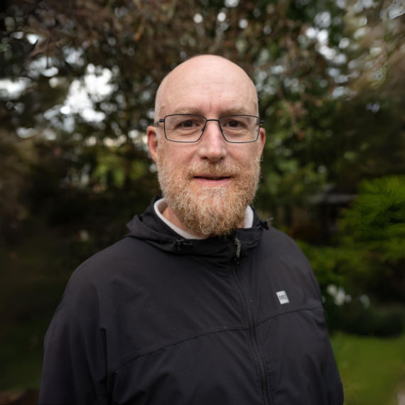 Tad McIlwraith stands outdoors posing for a photo. 