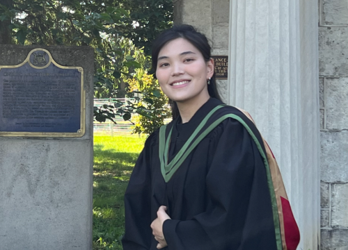 Tzu-Yi poses in front of the University of Guelph Portico wearing her graduation robes. 