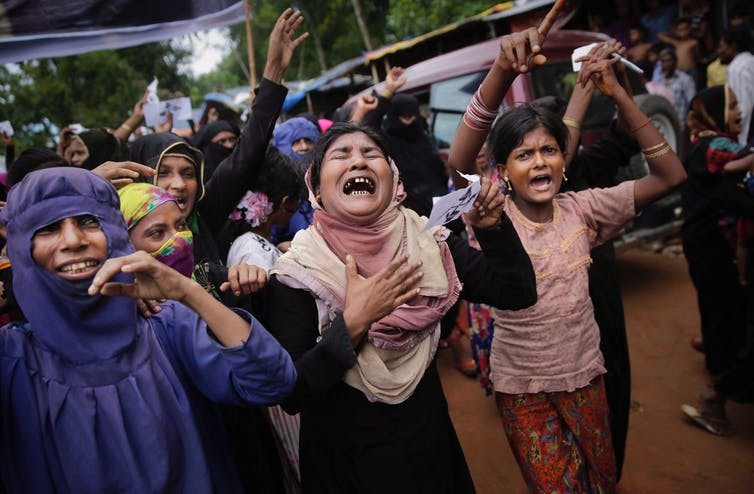 Rohingya women cry during a protest rally, August 2018